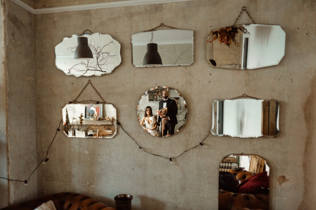 Married couple posing in front of mirrors.